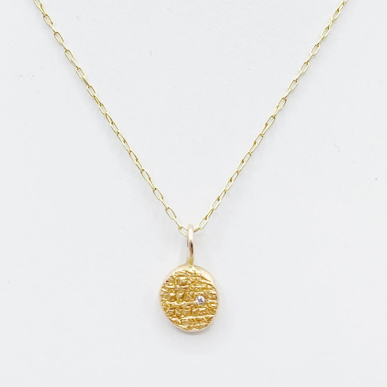 Diamond Embedded in a Textured Coin Shape